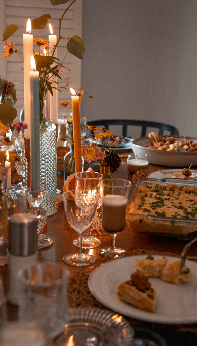 A candlelit supper table with glassware and shared plates
