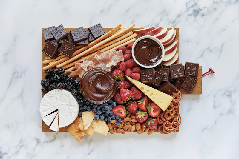 Dessert board with dark chocolate, berries, strawberries, brie and chocolate dip