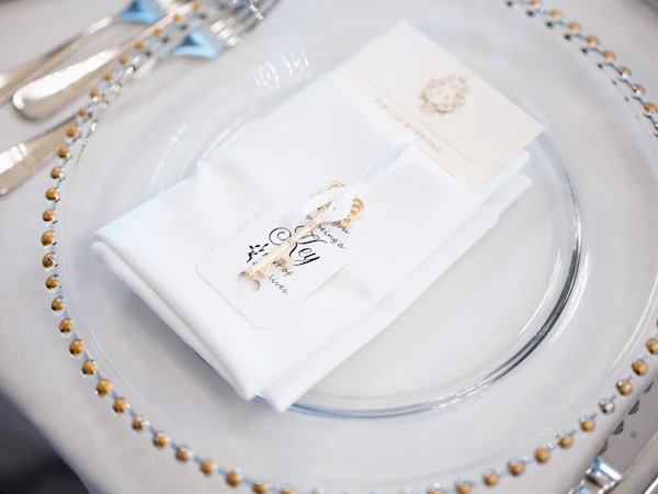 Place setting on a gold beaded charger with a white napkin