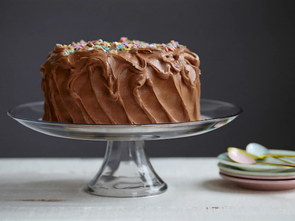 Chocolate cake on a footed glass cake stand