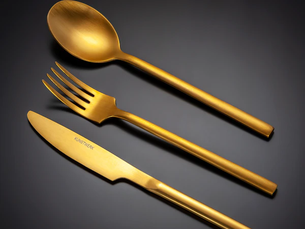 Gold fork, knife and spoons on a black background