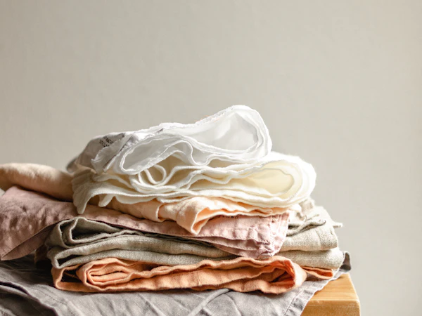 A stack of folded linen napkins in soft neutral tones