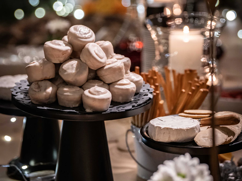 Cheeses and pastries on a candlelit table with glowing bokeh